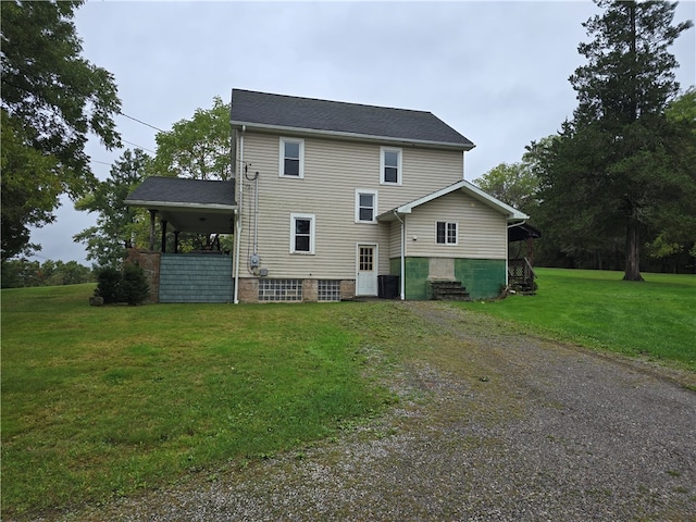 rear view of property featuring a lawn