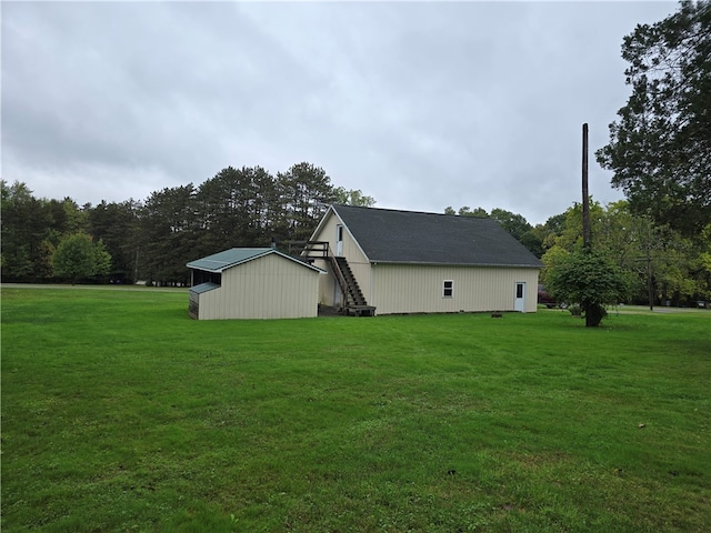 view of side of home featuring a yard and an outbuilding