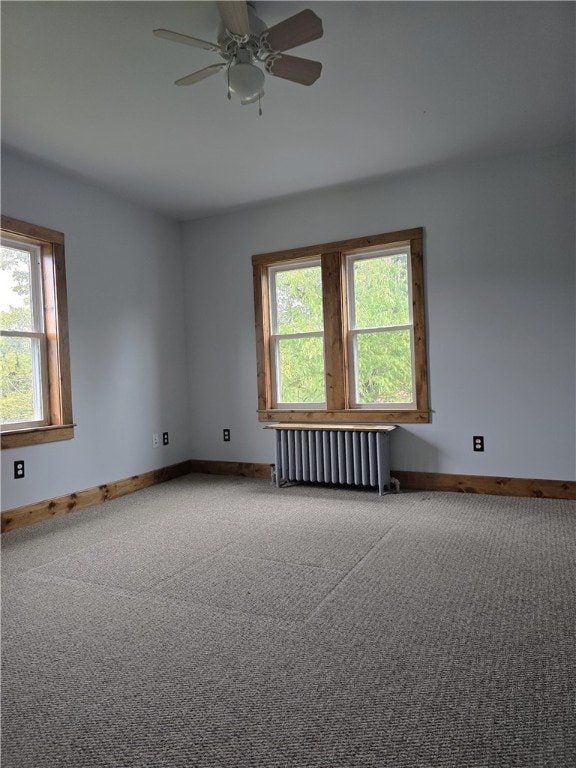 unfurnished room featuring radiator heating unit, carpet, and ceiling fan