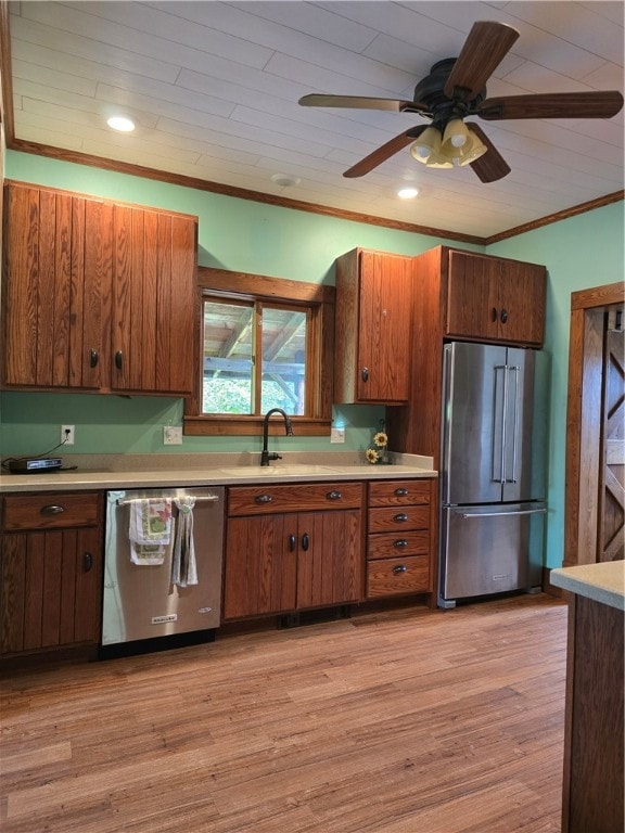 kitchen featuring stainless steel appliances, ceiling fan, light wood-type flooring, and crown molding