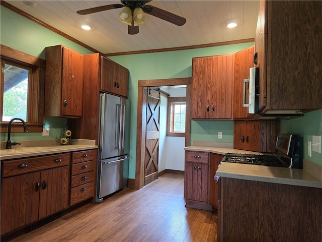 kitchen featuring light hardwood / wood-style flooring, a wealth of natural light, appliances with stainless steel finishes, and sink