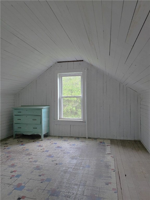 bonus room featuring light hardwood / wood-style flooring, wooden walls, lofted ceiling, and wooden ceiling