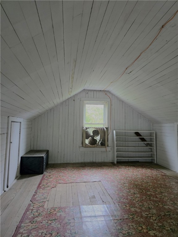 bonus room featuring wood ceiling, lofted ceiling, wooden walls, and light hardwood / wood-style flooring