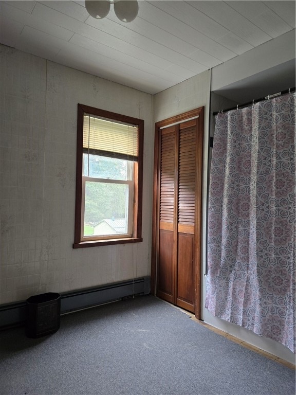 interior space with carpet flooring and a baseboard heating unit