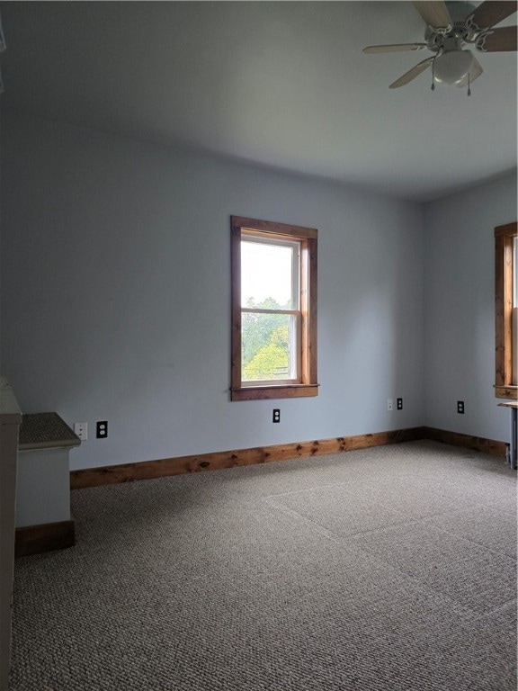 carpeted empty room featuring ceiling fan