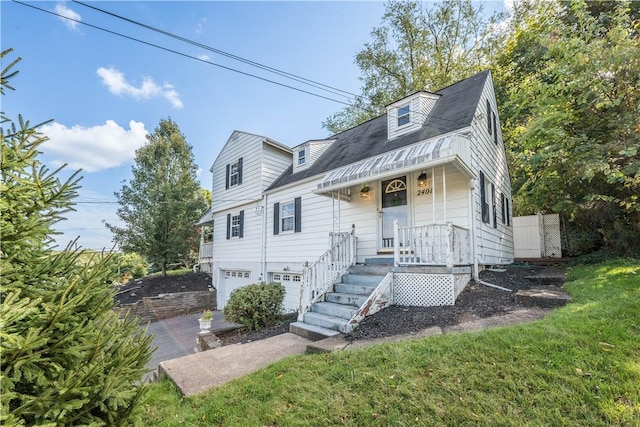 cape cod home with a front yard and a garage