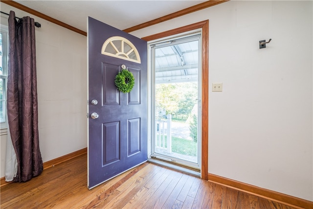 entrance foyer with crown molding, plenty of natural light, and hardwood / wood-style flooring