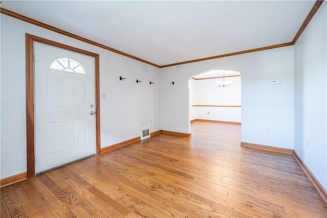 entrance foyer with light wood-type flooring, crown molding, and a notable chandelier