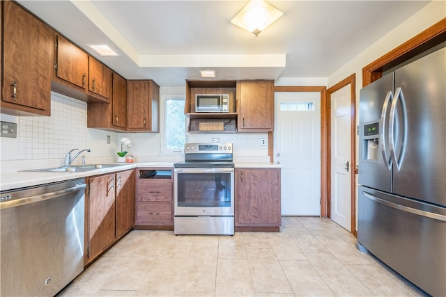 kitchen featuring a healthy amount of sunlight, sink, light tile patterned floors, and stainless steel appliances