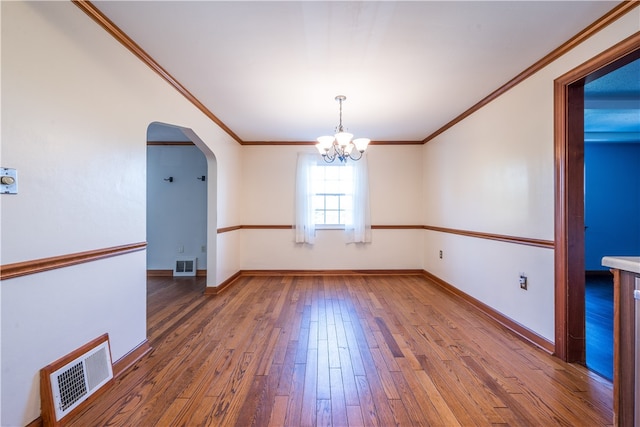 unfurnished dining area with dark hardwood / wood-style flooring, crown molding, and an inviting chandelier