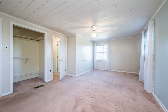 unfurnished bedroom featuring ornamental molding, a closet, ceiling fan, and light colored carpet