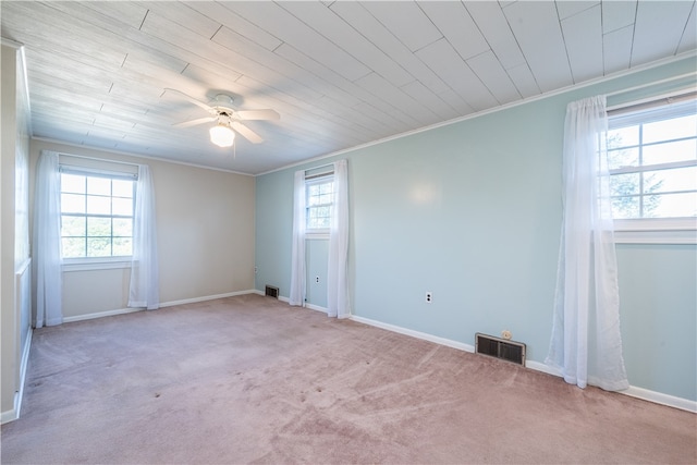 carpeted empty room featuring ceiling fan, ornamental molding, and wood ceiling