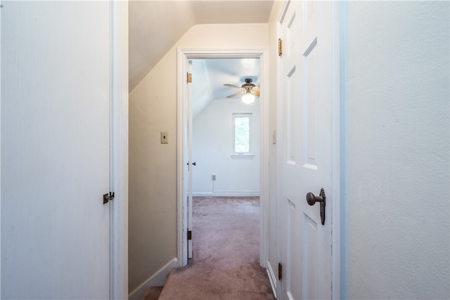 hallway with lofted ceiling and light carpet