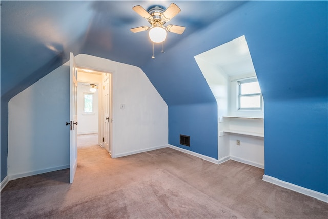 additional living space featuring ceiling fan, lofted ceiling, and light carpet