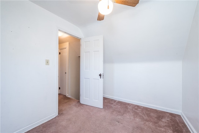 interior space with ceiling fan, light colored carpet, and vaulted ceiling