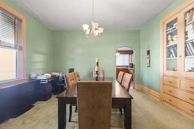 carpeted dining room with a chandelier and a wealth of natural light