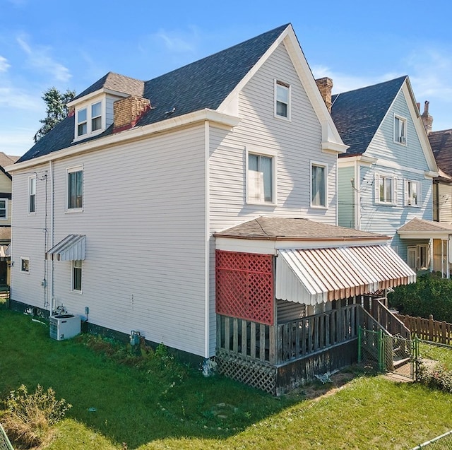 back of property with a yard and central air condition unit