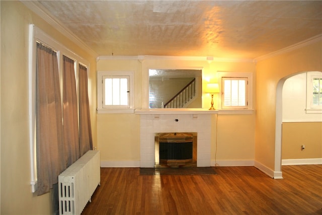 unfurnished living room with ornamental molding, radiator, plenty of natural light, and hardwood / wood-style flooring