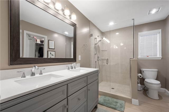 bathroom with toilet, vanity, an enclosed shower, and hardwood / wood-style flooring