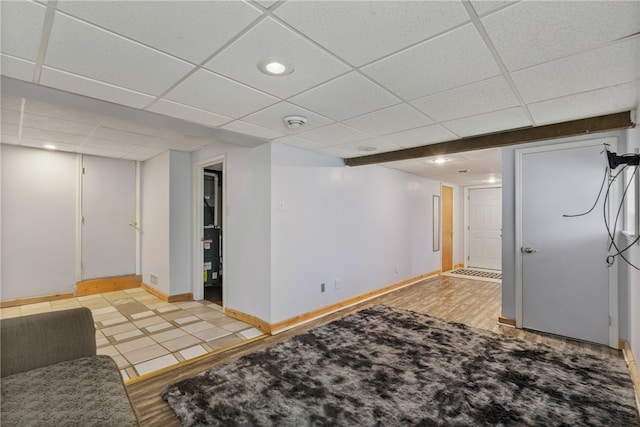 basement featuring a drop ceiling and light wood-type flooring