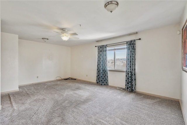 carpeted empty room with visible vents, ceiling fan, and baseboards