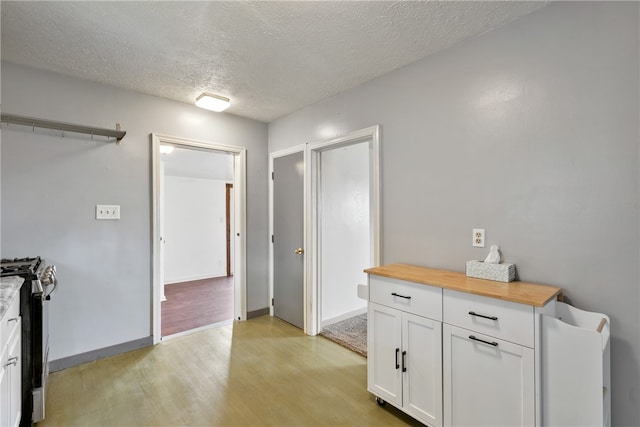 corridor featuring light hardwood / wood-style flooring and a textured ceiling