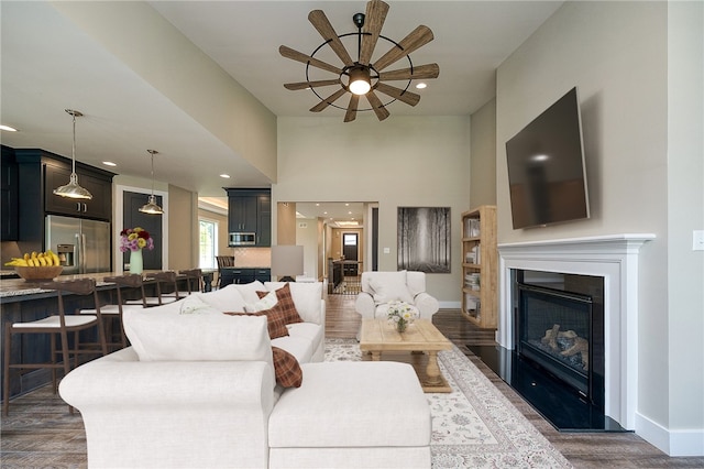 living room with ceiling fan and dark hardwood / wood-style floors