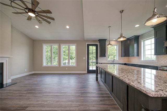 kitchen featuring a healthy amount of sunlight, a center island, dark hardwood / wood-style flooring, and tasteful backsplash