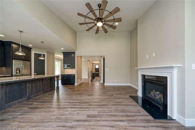 unfurnished living room with ceiling fan and dark wood-type flooring