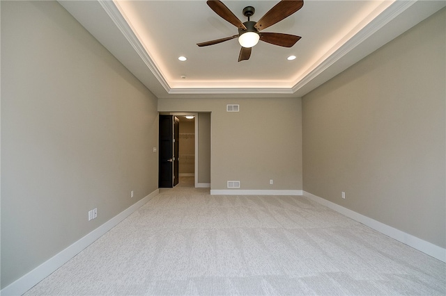 carpeted spare room featuring ceiling fan and a tray ceiling