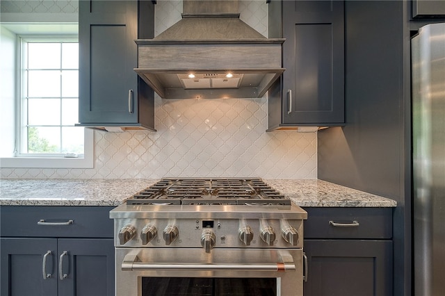 kitchen featuring light stone countertops, appliances with stainless steel finishes, tasteful backsplash, and a healthy amount of sunlight