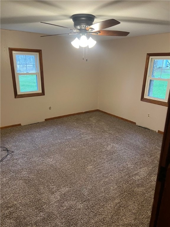 spare room featuring carpet, ceiling fan, and a wealth of natural light