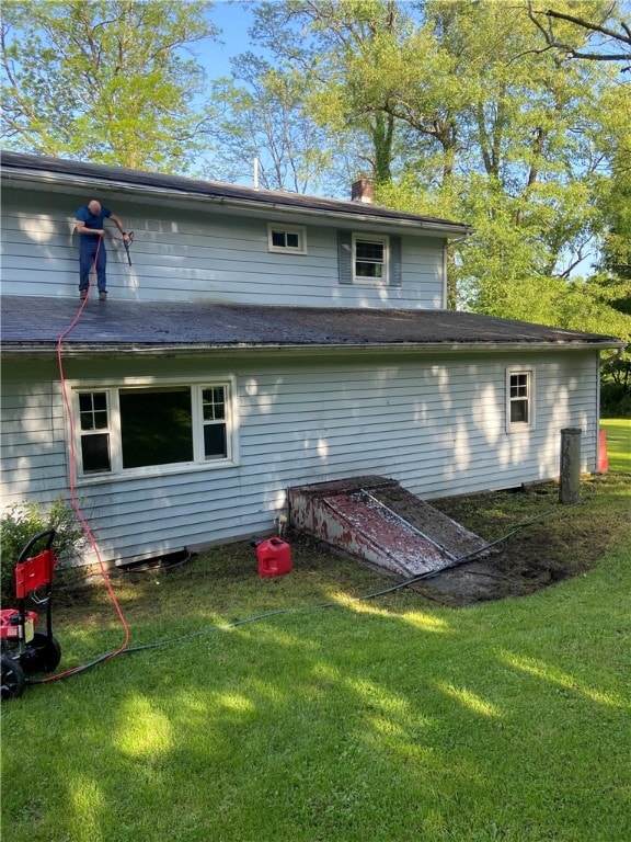 rear view of property with a lawn