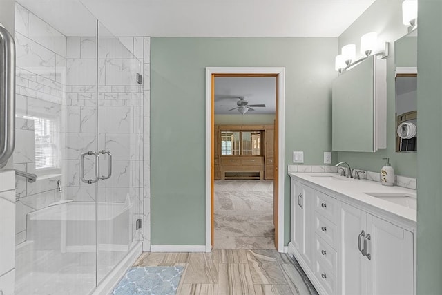 bathroom with ceiling fan, a shower with door, and vanity