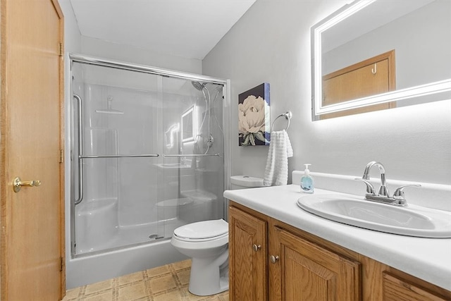 bathroom with vanity, toilet, and a shower with shower door