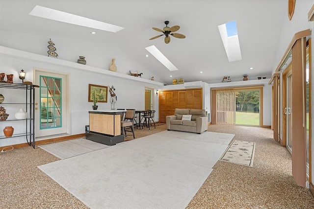 living room with ceiling fan, high vaulted ceiling, and light carpet