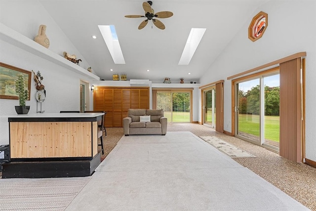 carpeted living room featuring bar area, high vaulted ceiling, and ceiling fan