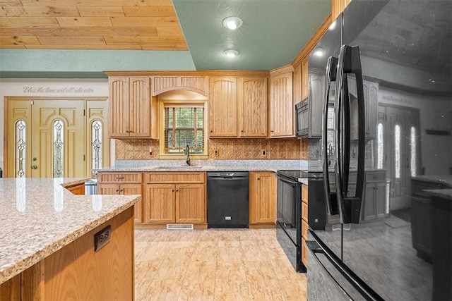 kitchen with light stone countertops, tasteful backsplash, sink, black appliances, and wooden ceiling