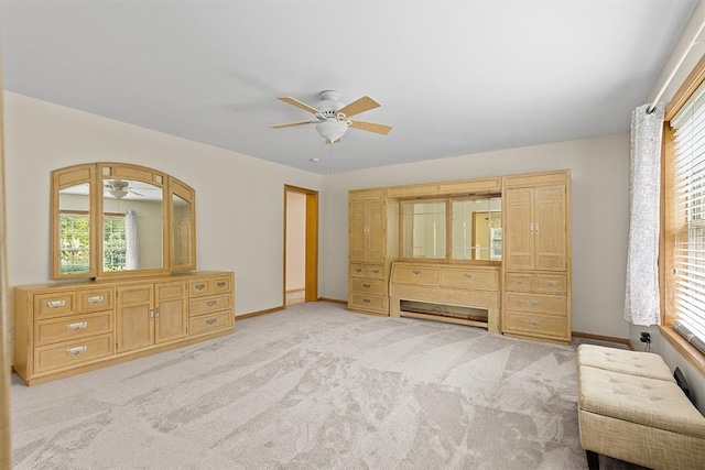 unfurnished bedroom with ceiling fan, light carpet, and multiple windows