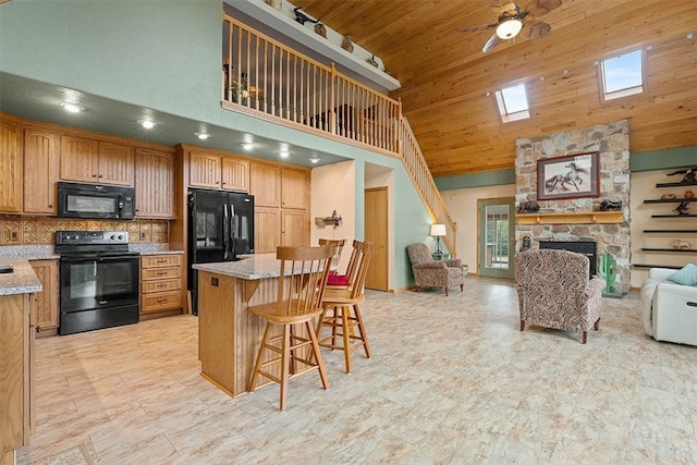 kitchen featuring wooden ceiling, high vaulted ceiling, black appliances, decorative backsplash, and a kitchen bar