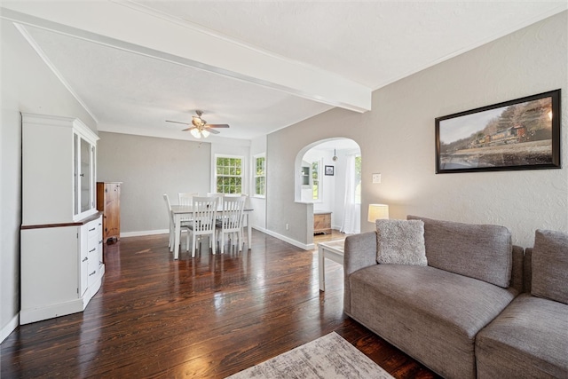 living room with dark wood-type flooring, beamed ceiling, and ceiling fan