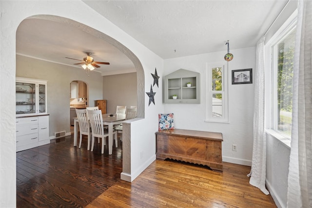 dining area with wood-type flooring, ornamental molding, and ceiling fan