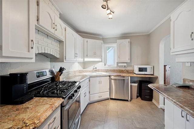 kitchen featuring white cabinets, appliances with stainless steel finishes, crown molding, and sink