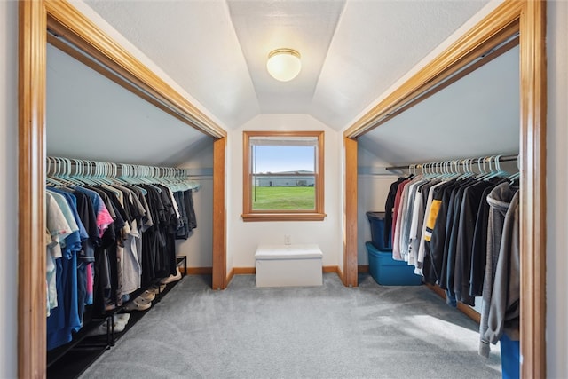 walk in closet with vaulted ceiling and carpet