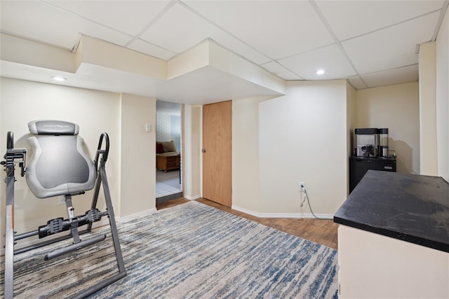 workout room with hardwood / wood-style flooring and a drop ceiling