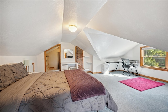 bedroom with a textured ceiling, lofted ceiling, and light colored carpet