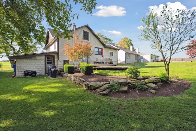 back of house featuring a wooden deck and a lawn