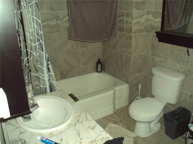 full bathroom featuring shower / tub combo with curtain, tile walls, sink, and toilet