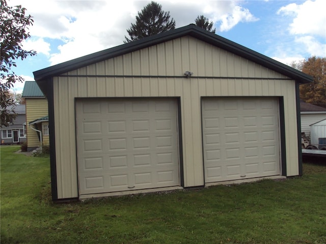 garage featuring a yard and wooden walls