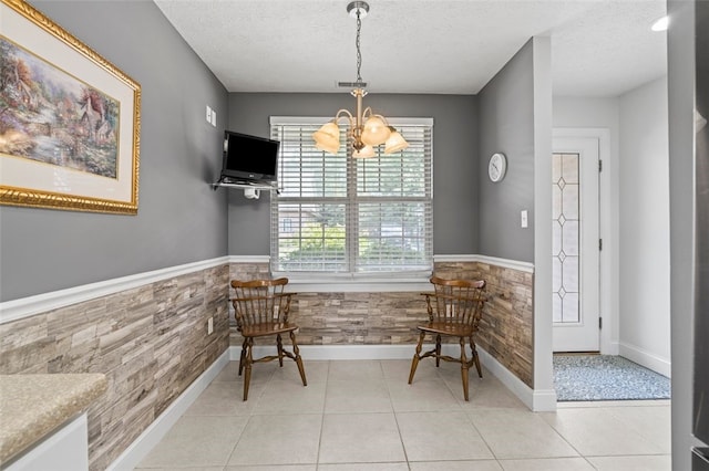 sitting room with light tile patterned floors, a textured ceiling, and a notable chandelier